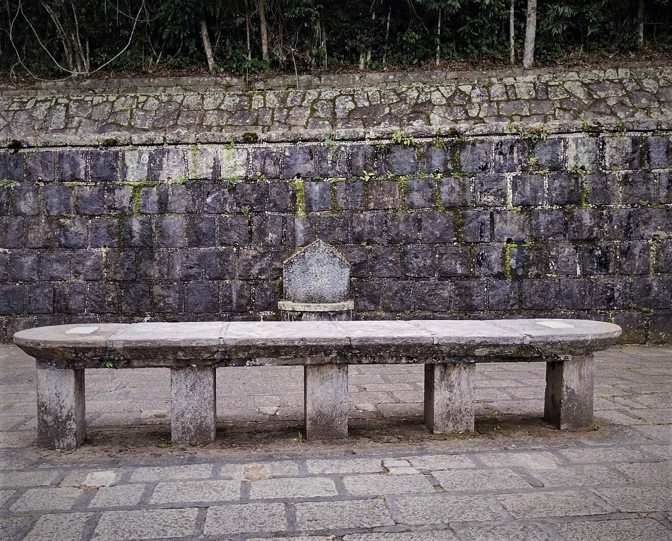 Historic stone table at Mesa do Imperador, surrounded by Atlantic Forest.